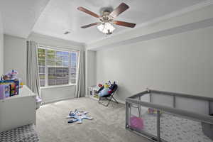Unfurnished bedroom featuring carpet, a textured ceiling, crown molding, and a ceiling fan