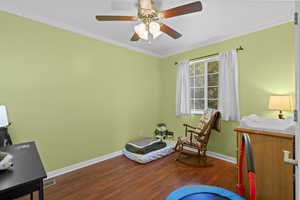 Living area featuring wood finished floors, ornamental molding, and a ceiling fan