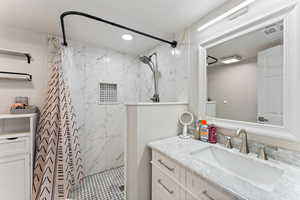 Bathroom featuring vanity, a shower stall, and recessed lighting