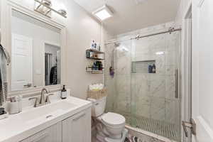 Full bathroom with a marble finish shower and vanity