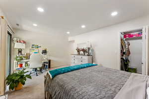 Carpeted bedroom with recessed lighting, an office area, and a walk in closet