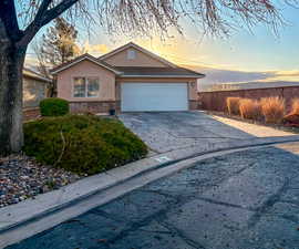 View of front of home featuring brick siding, stucco siding, driveway, a garage, and a tile roof