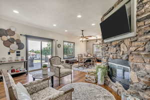 Living room with wood finished floors, recessed lighting, and a ceiling fan