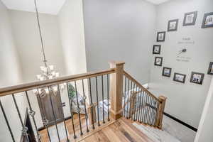 Stairs featuring a chandelier and wood finished floors