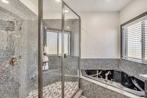 Bathroom with a stall shower and a jetted tub
