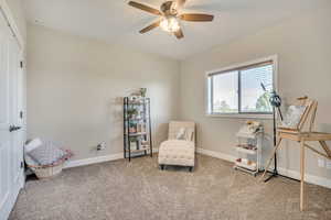Sitting room featuring carpet floors and a ceiling fan