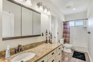 Full bathroom featuring vanity, shower / tub combo, and wood finished floors