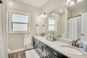 Full bath with double vanity and wood finished floors