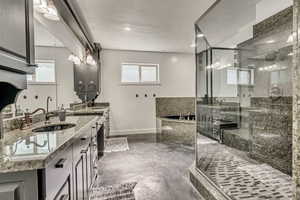 Bathroom with a bath, a stall shower, vanity, and concrete flooring