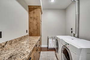Laundry area with washer and clothes dryer, cabinet space, and recessed lighting