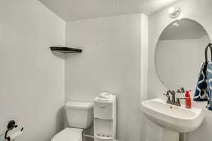 Bathroom featuring a sink and a textured ceiling
