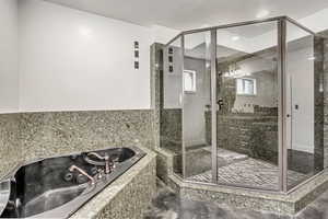 Full bathroom featuring a whirlpool tub, a stall shower, and marble finish floors