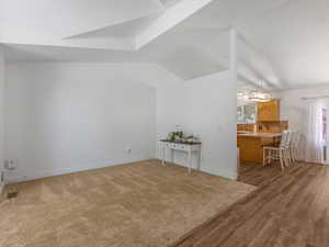 Additional living space with lofted ceiling and baseboards