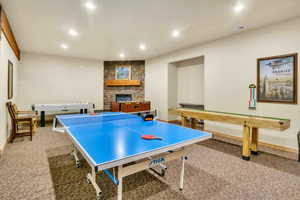 Game room with carpet, recessed lighting, and a stone fireplace
