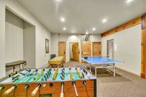 Recreation room featuring light carpet, recessed lighting, and arched walkways