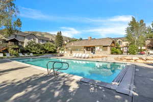 Community pool with a patio area, a residential view, and a mountain view