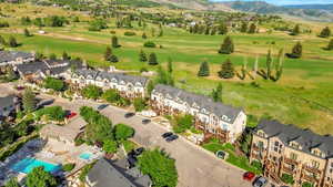 Aerial perspective of suburban area featuring a mountain backdrop and a golf course