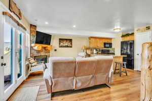Living room featuring a fireplace, light wood-style floors, and recessed lighting