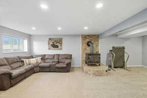 Carpeted living area with a wood stove and recessed lighting