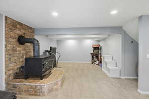 Sitting room featuring carpet floors, a wood stove, and recessed lighting