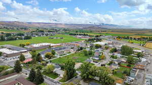 Aerial view of property and surrounding area with mountains and nearby suburban area