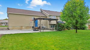 Back of property with a lawn, a patio, a pergola, roof with shingles, and a chimney
