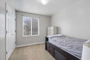 Bedroom featuring light carpet and a closet