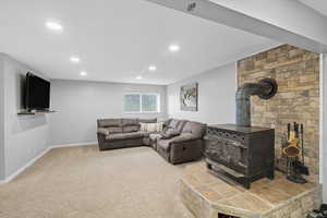 Carpeted living area with a wood stove and recessed lighting