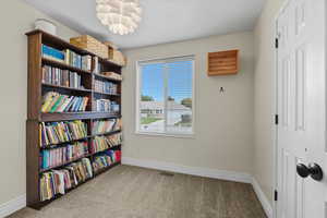 Living area featuring light colored carpet and baseboards
