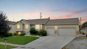 Single story home with a lawn, driveway, a garage, and brick siding