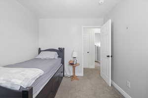 Bedroom featuring light colored carpet and a textured ceiling