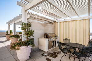 Rooftop patio / terrace with area for grilling, a pergola, and outdoor dining space