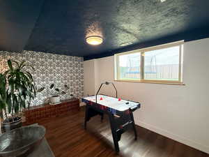 Recreation room with wood finished floors and baseboards