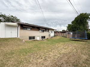 Rear view of property featuring a trampoline and brick siding