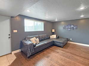 Living area featuring a textured ceiling, wood finished floors, and recessed lighting