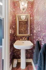 Bathroom featuring wood finished floors and wallpapered walls