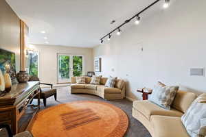 Living area featuring carpet flooring, track lighting, and recessed lighting