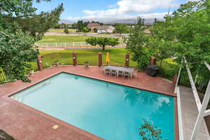 View of swimming pool with a patio area and a mountain view