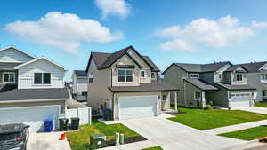 View of front facade with board and batten siding, a residential view, a garage, and driveway