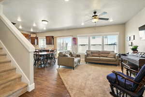 Living area with a ceiling fan, wood finished floors, stairway, and recessed lighting