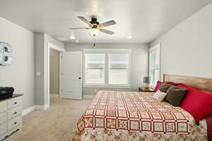 Bedroom with light colored carpet and ceiling fan