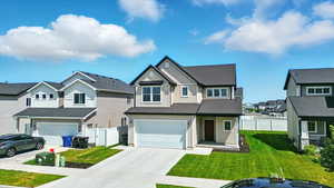 View of front of property with board and batten siding, concrete driveway, a garage, and a residential view