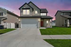 View of front facade featuring board and batten siding, an attached garage, and concrete driveway