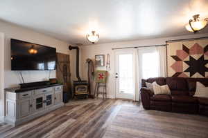 Living room with a wood stove and wood finished floors