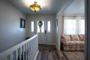 Foyer featuring dark wood-type flooring and baseboards