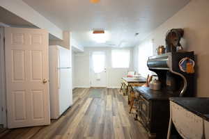 Kitchen featuring freestanding refrigerator, wood finished floors, and dark countertops