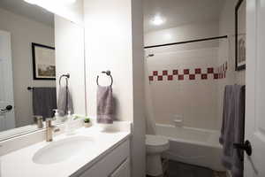 Full bathroom with vanity, shower / bath combination with curtain, and a textured ceiling