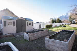 View of yard with a vegetable garden, a storage unit, and a mountain view
