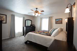 Bedroom with carpet, a ceiling fan, and a textured ceiling