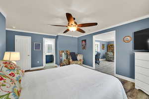 Bedroom with wood finished floors, ornamental molding, a ceiling fan, and ensuite bathroom